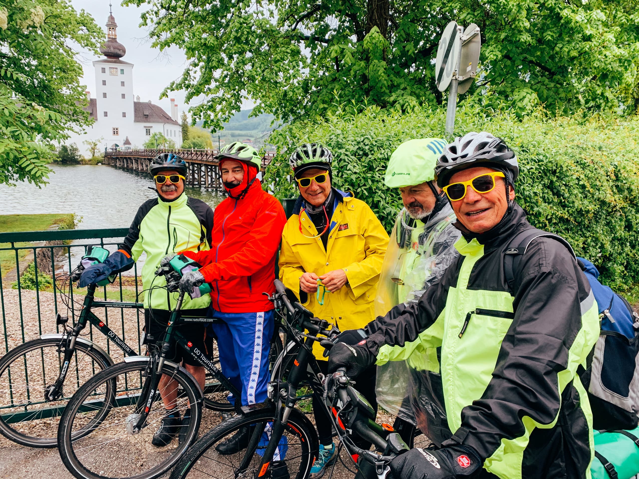 Gruppo di ciclisti con caschetto e impermeabile in una giornata di pioggia